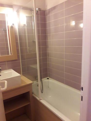 une salle de bain avec une baignoire et un lavabo dans l'établissement Moliets Plage Appartement pour 4 Piscine proche Plage et Commerces, à Moliets-et-Maa