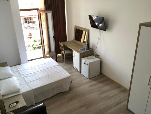 ein Schlafzimmer mit einem Bett und einem Schreibtisch mit Spiegel in der Unterkunft M-Rooms in Kobuleti
