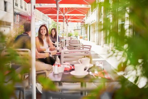 a group of people sitting at tables on a patio at Mercure Lyon Centre Plaza République in Lyon