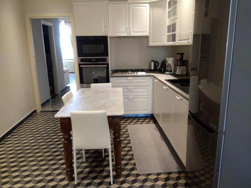 a kitchen with white cabinets and a table and chairs at oltremare soul houses in Chiavari