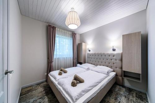 a bedroom with a large bed with two shoes on it at Olando Kepure in Karklė