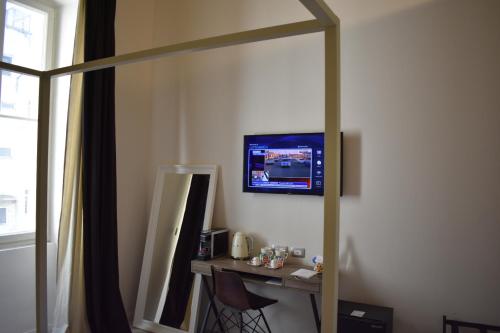 a room with a mirror and a table with a television at Gatto Bianco Duchessa in Bari