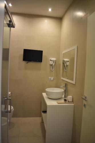 a bathroom with a sink and a tv on the wall at Gatto Bianco Duchessa in Bari