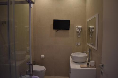 a bathroom with a sink and a toilet and a television at Gatto Bianco Duchessa in Bari