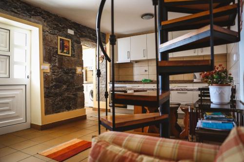 eine Küche und ein Wohnzimmer mit einer Wendeltreppe in der Unterkunft Raposeira Chloe T2 in Fajã da Ovelha