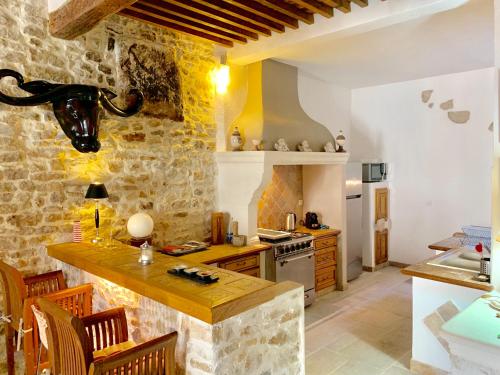 une cuisine avec un mur en pierre et un comptoir dans l'établissement Authentique Bijou Cœur d’Orange à 2 pas du Théâtre Antique!, à Orange
