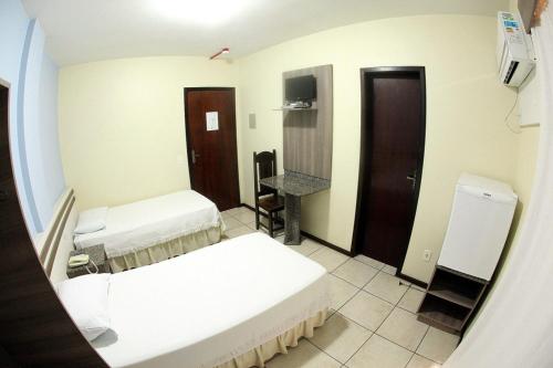a hospital room with two beds and a mirror at Hotel Germânia Nova Veneza in Nova Veneza