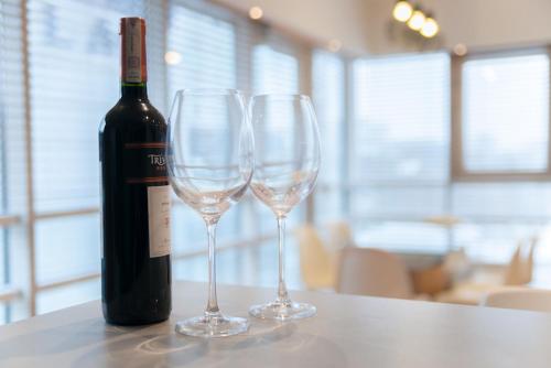 ワルシャワにあるプラチナム タワーズ カントリー トゥー カントリーのワイン1本とワイングラス2杯(テーブル上)