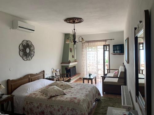 a bedroom with a bed and a living room at Iliovolo Guesthouse in Miléai