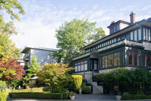 a black and white house with trees and bushes at Beaconsfield Bed and Breakfast - Victoria in Victoria