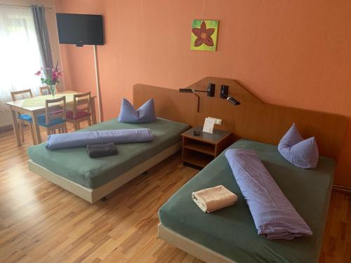 2 Betten in einem Zimmer mit einem Tisch und einer Tableablishthritisthritisthritisthritisthritis in der Unterkunft Pension Scheffler in Potsdam