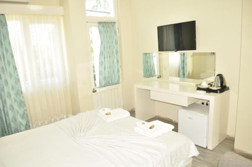 a white room with a bed and a mirror at Kemer Park Otel in Kemer