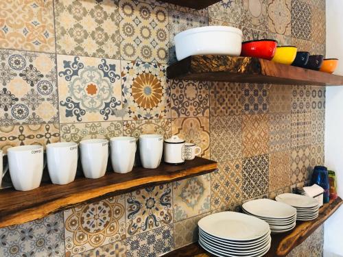 a bunch of cups and plates on a shelf at Casa Bizu in Bacalar