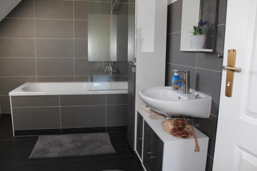 a bathroom with a sink and a bath tub at Spreewald Unterkünfte in Briesensee