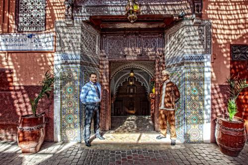 a painting of two men walking through a doorway at Riad Dar Essalam in Marrakesh