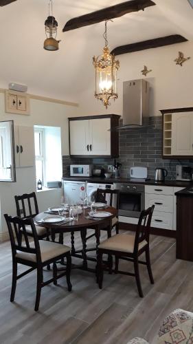 a kitchen with a table and chairs and a dining room at Swallows Cottage in Swinford