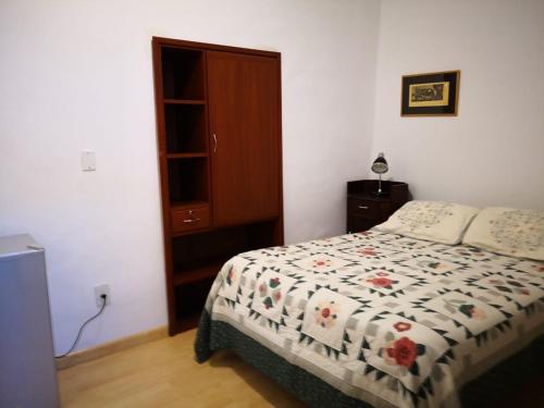 1 dormitorio con 1 cama con edredón de flores en Casa Colonial, en Tarija
