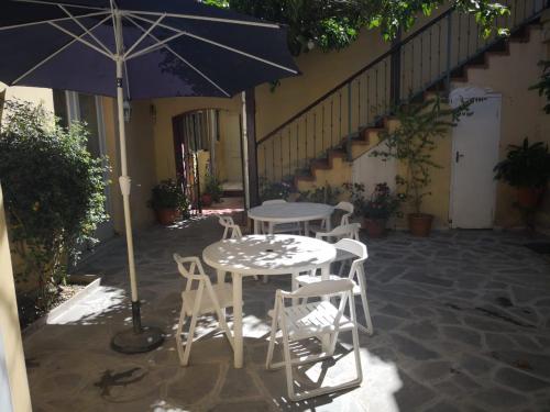 una mesa, sillas y una sombrilla en el patio en Casa Colonial, en Tarija