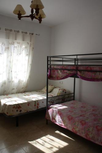 1 dormitorio con 2 literas y ventana en Lidia LOCDENIA, en Els Poblets