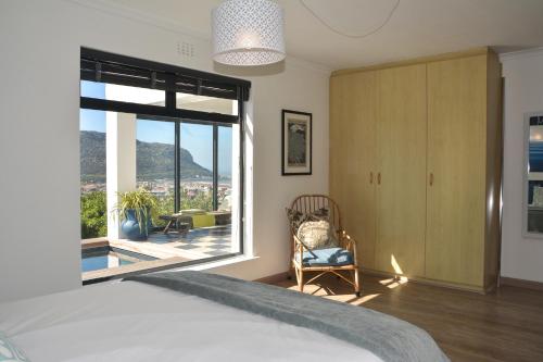 Un dormitorio con una cama y una ventana grande. en Luxury Modern House Western Cape Fish Hoek, en Ciudad del Cabo