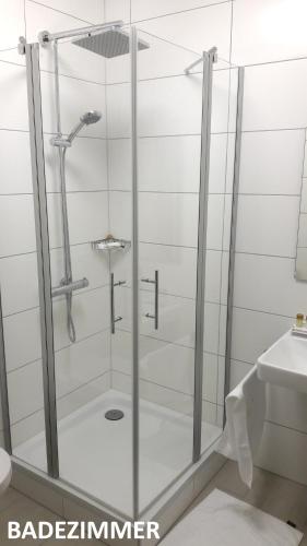 a shower with a glass door in a bathroom at Nashira Kurpark Hotel in Bad Herrenalb