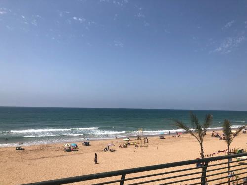 a group of people on a beach with the ocean at Luxury Apartement Near the Beach in Sidi Bouqnadel