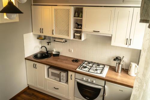 a kitchen with white cabinets and a stove top oven at Apartment Old Brest in Brest