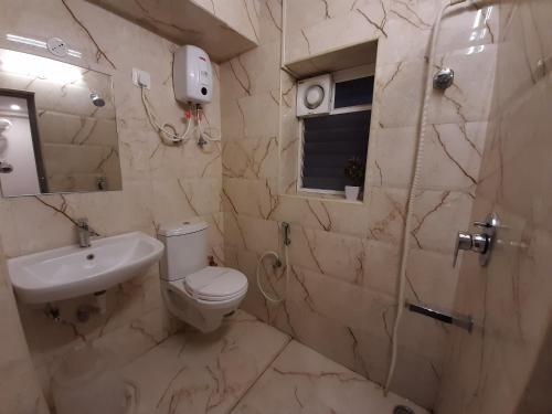 a bathroom with a toilet and a sink and a shower at Liza Regency in Chennai