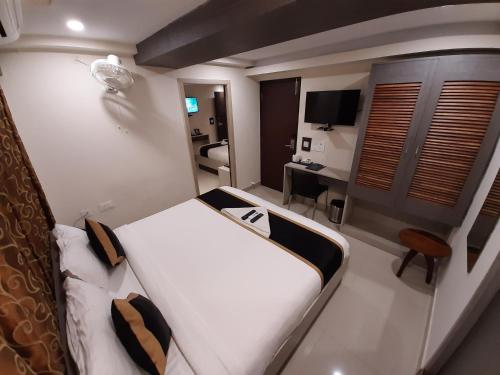 a hotel room with a bed and a desk at Liza Regency in Chennai