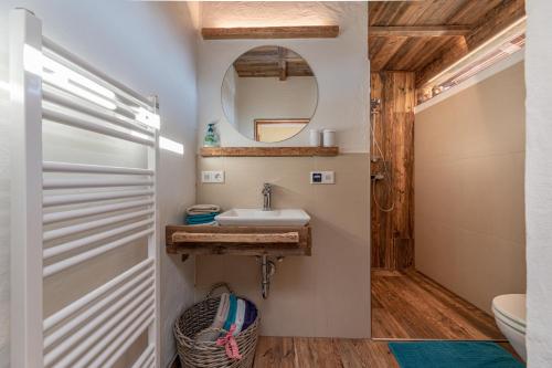 ein Bad mit einem Waschbecken und einem Spiegel in der Unterkunft Tom's Jägerlodge in Jenig