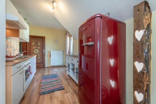a kitchen with a red refrigerator with hearts on it at Tom's Jägerlodge in Jenig