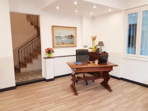 an office with a wooden desk and a staircase at Hotel Bel Sit in Rapallo