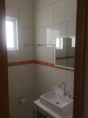 a bathroom with a sink and a mirror at Amsterdam lofts 4 in Poços de Caldas