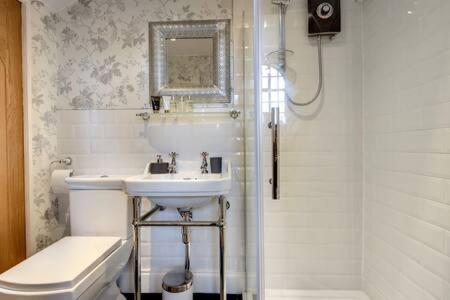 a bathroom with a sink and a toilet and a shower at Carnegie Library: Bronte Apartment 1 bedroom in Swinton