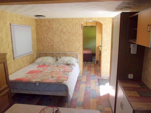 a bedroom with a bed with two pillows on it at Mobil-home in Ravières