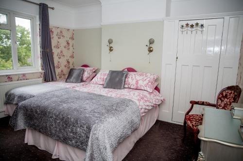 a bedroom with two beds and a window at Bay Tree House Bed & Breakfast in Barnet