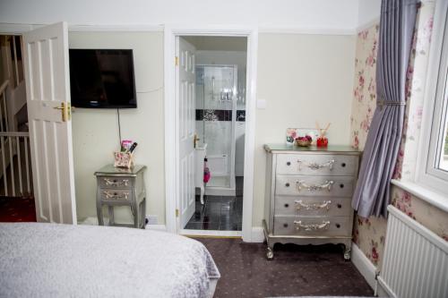 a bedroom with a bed and a dresser and a mirror at Bay Tree House Bed & Breakfast in Barnet