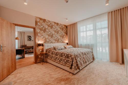 a bedroom with a bed and a large window at Villa Garden Apartments in Poprad
