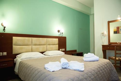 a bedroom with a bed with towels on it at Hotel Solon in Tolo