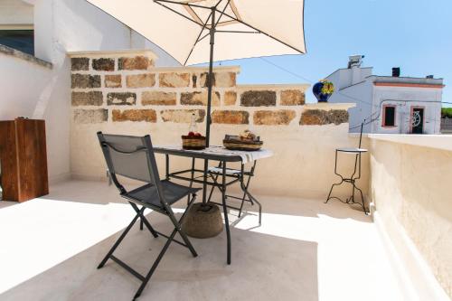 a table and chair on a balcony with an umbrella at Il Galletto bb in Patù