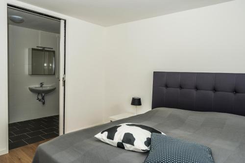 een slaapkamer met een bed, een wastafel en een spiegel bij Chaletparc Krabbenkreek Zeeland - Chalet 94 in Sint Annaland