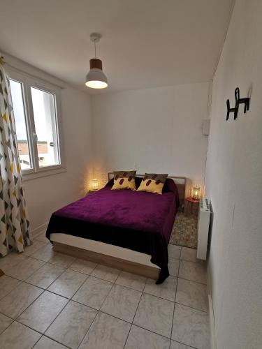 - une chambre avec un lit doté de draps et d'oreillers violets dans l'établissement appartement vue sur mer, à Saint-Jean-de-Monts
