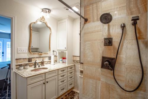 a bathroom with a shower and a sink and a mirror at Comfortable, Family and Business Friendly 2BD/2BA House in North Austin in Austin