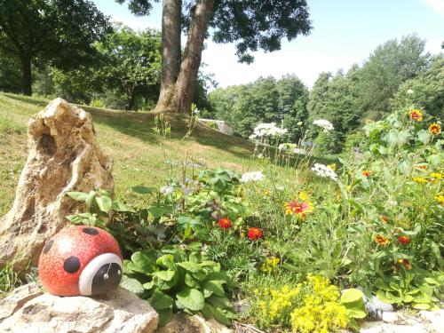 a garden with a stuffed animal sitting on a rock at Le Clos du Buisson in Saint-Julien-de-la-Liègue