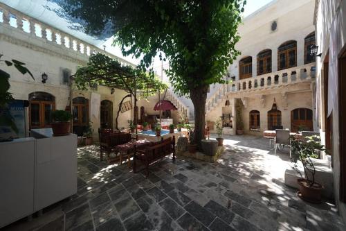 a courtyard with a table and a tree in a building at ŞarkÇırağan Konak Boutique Hotel in Urfa
