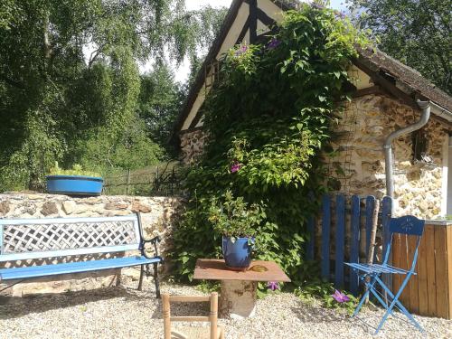 a blue bench sitting in front of a stone building at Le Clos du Buisson in Saint-Julien-de-la-Liègue