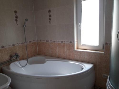 a white bath tub in a bathroom with a window at Садиба "Ековид" in Krivorovnya