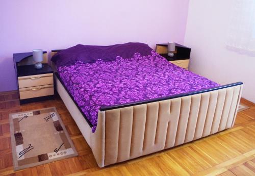a bed with purple sheets on it in a room at ASTREA in Rijeka