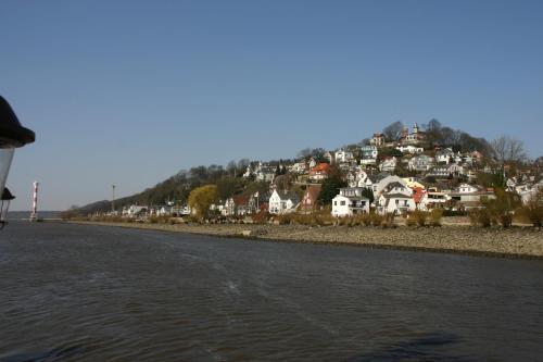 a town on a hill next to a body of water at Hotel Kreuzer in Wedel