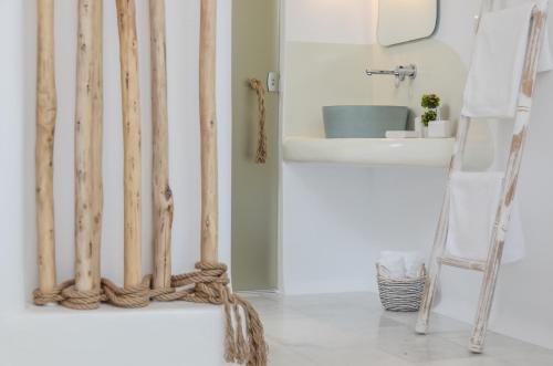 a bathroom with bamboo poles and a sink at Maroussa Studios in Agia Anna Naxos